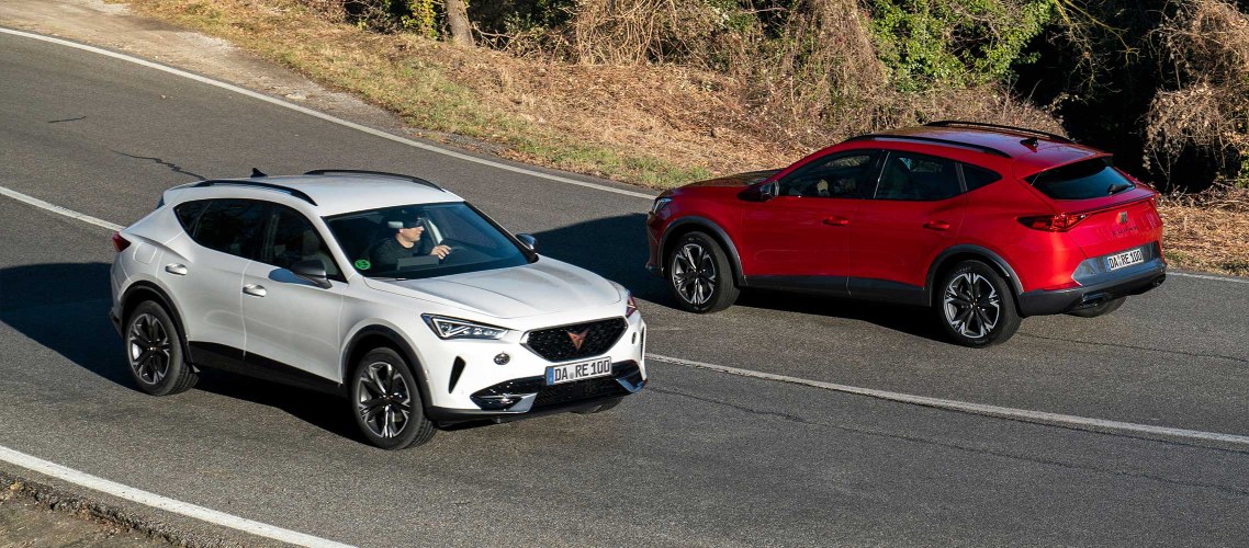 Seitenansicht von zwei fahrenden CUPRA Formentoren in weiß und in rot. 