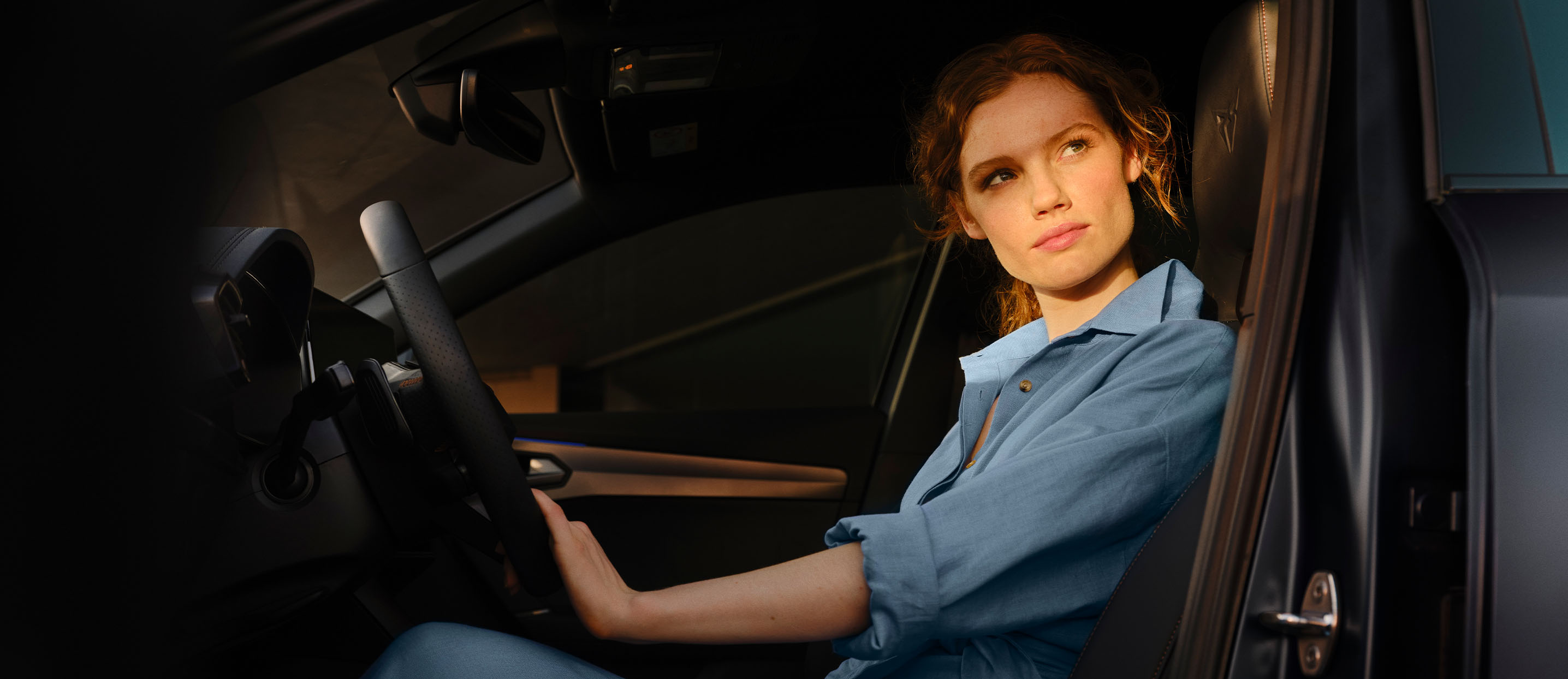 Eine Frau sitzt am Lenkrad eines CUPRA Fahrzeugs.