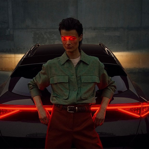 Ein CUPRA Fahrzeug steht auf einem Parkplatz vor einer hellen Wand. 