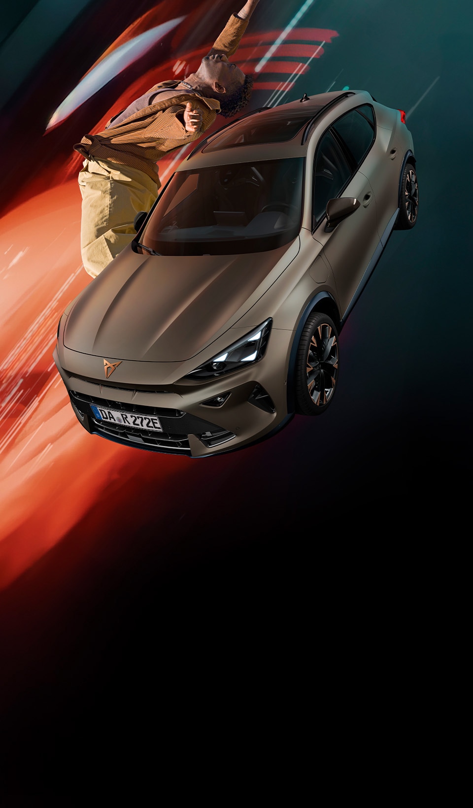 A CUPRA Formentor CUV suspended diagonally, next to a rocky, cliff-like structure. A charging cable is connected to the car from a charging unit on the cliff face.
