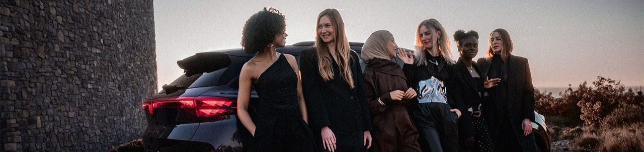 Eine Gruppe von Frauen lehnt an einem CUPRA Terramar in einer Landschaft bei Abendlicht.