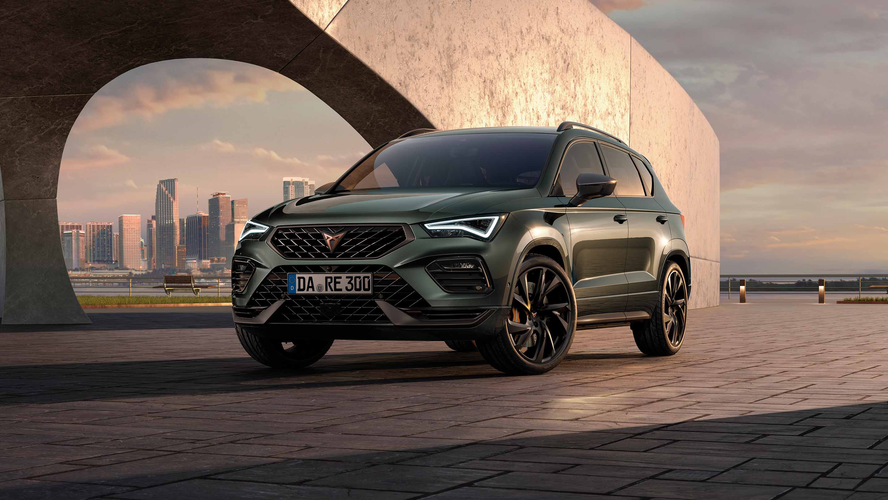 Eine Person geht auf den CUPRA Ateca zu und zeigt dabei die markanten, athletischen Linien und die dynamische Form des Fahrzeugs, die den Spirit des CUPRA Tribes verkörpern.