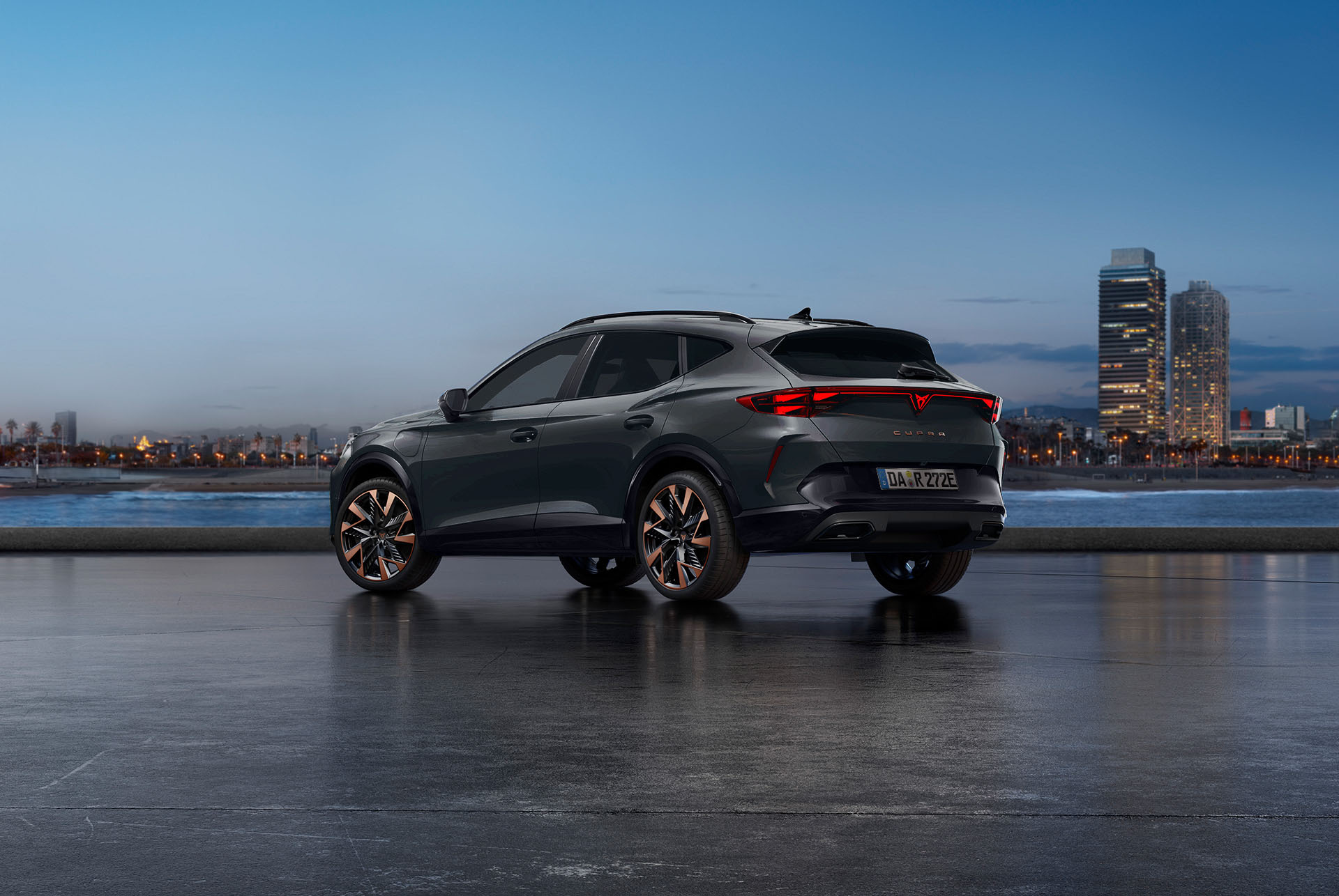 Ein neuer CUPRA Formentor in Century Bronze Matt, geparkt an einer Uferpromenade in der Dämmerung. Im Hintergrund ist eine Stadtlandschaft mit Wolkenkratzern und Palmen zu sehen, die vom schwindenden Licht des Tages beleuchtet werden.