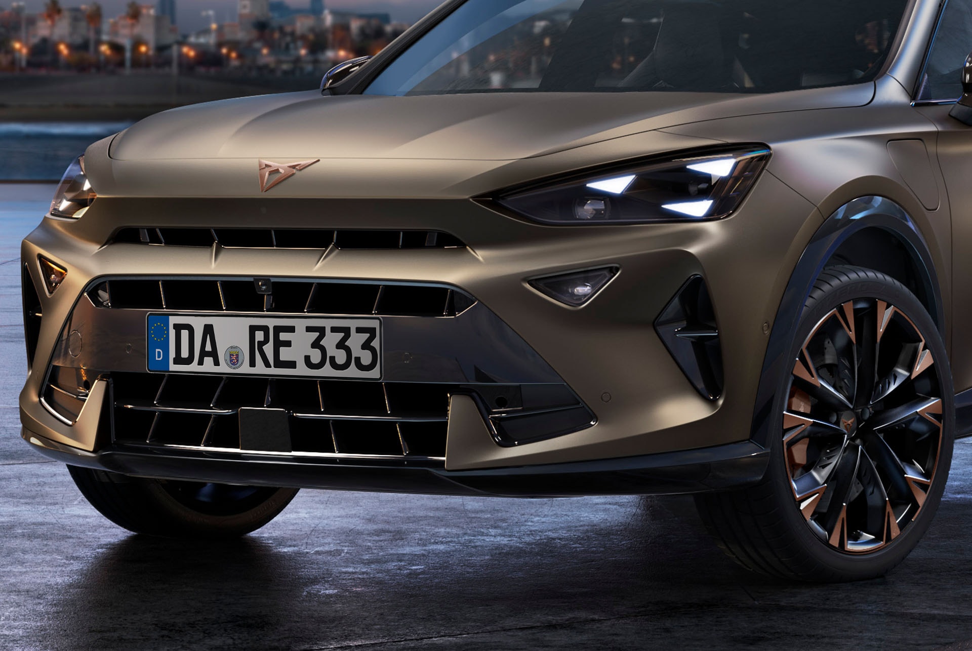 Nahaufnahme der Vorderseite des CUPRA Formentor in Bronze mit kupferfarbenen Felgen, den charakteristischen Frontscheinwerfern und dem markanten CUPRA-Logo.