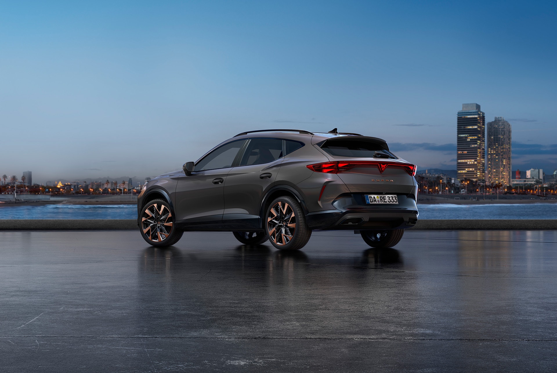 Ein neuer CUPRA Formentor in Century Bronze Matt, geparkt an einer Uferpromenade in der Dämmerung. Im Hintergrund ist eine Stadtlandschaft mit Wolkenkratzern und Palmen zu sehen, die vom schwindenden Licht des Tages beleuchtet werden.