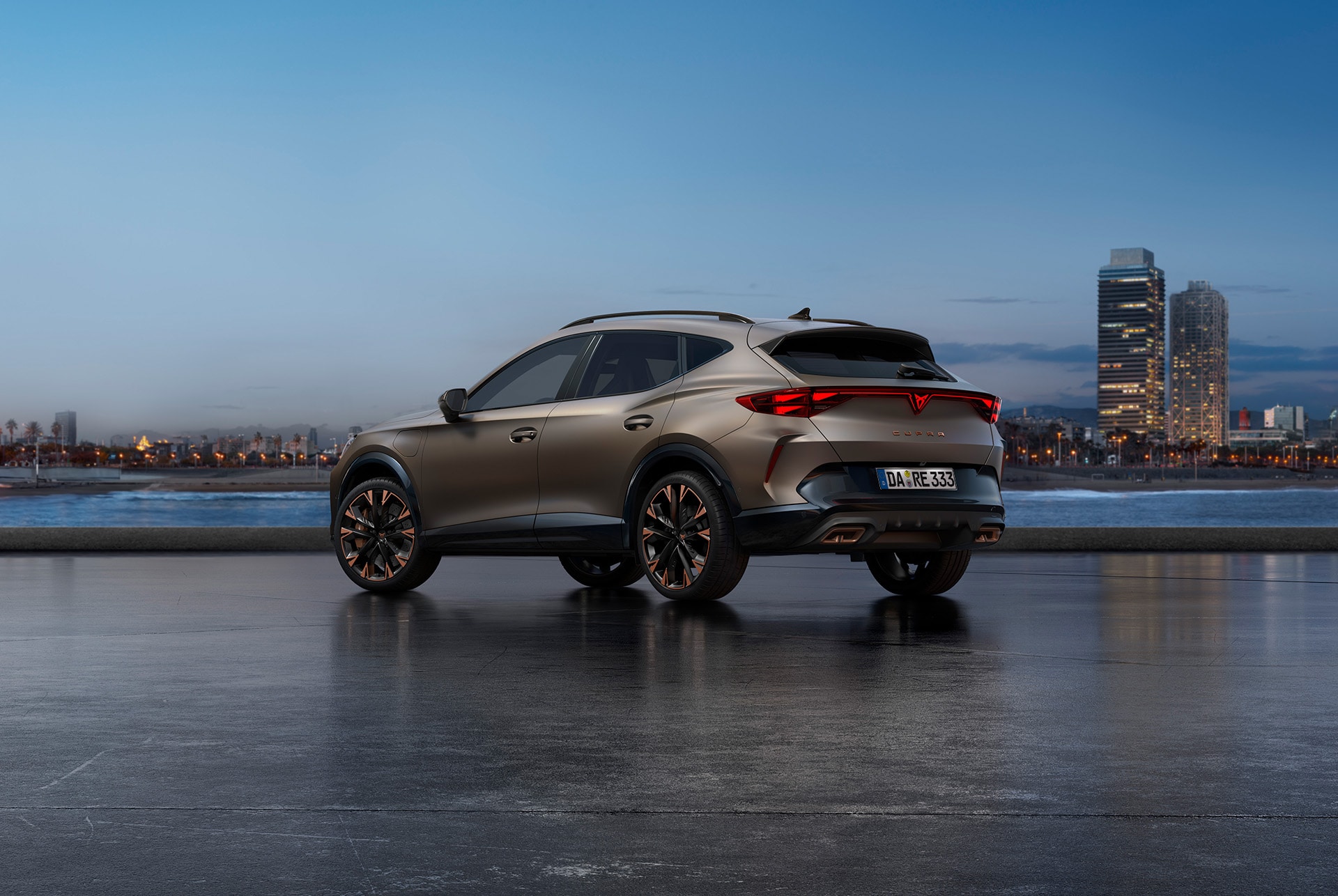 Ein neuer CUPRA Formentor in Century Bronze Matt, geparkt an einer Uferpromenade in der Dämmerung. Im Hintergrund ist eine Stadtlandschaft mit Wolkenkratzern und Palmen zu sehen, die vom schwindenden Licht des Tages beleuchtet werden.