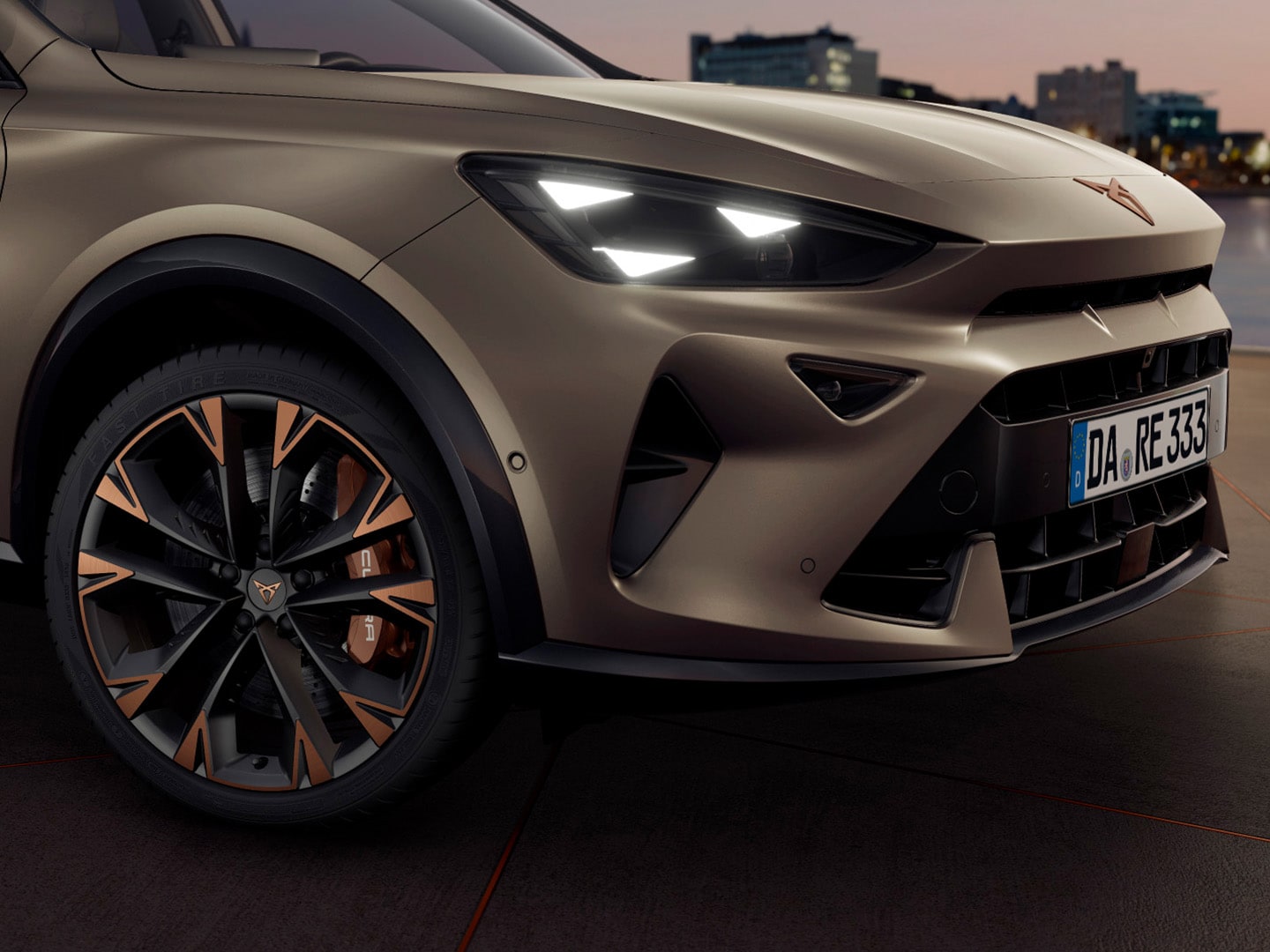 Nahaufnahme der Frontpartie eines matt bronze-farbenen CUPRA Formentor mit markantem Kühlergrill und CUPRA-Logo