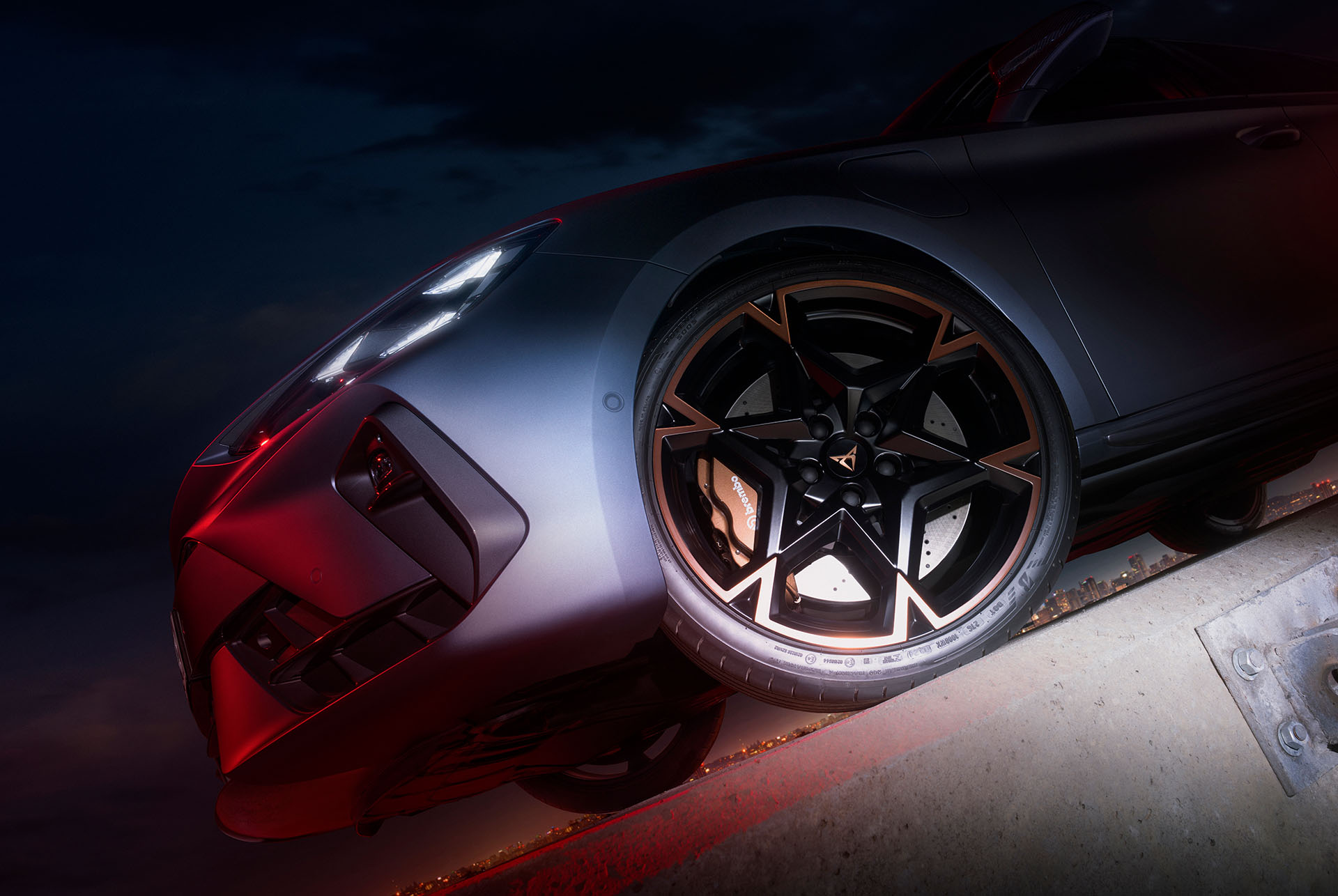 Nahaufnahme eines CUPRA Rads mit markantem Felgendesign und Brembo-Bremssystem, stilvoll beleuchtet in der Nacht.