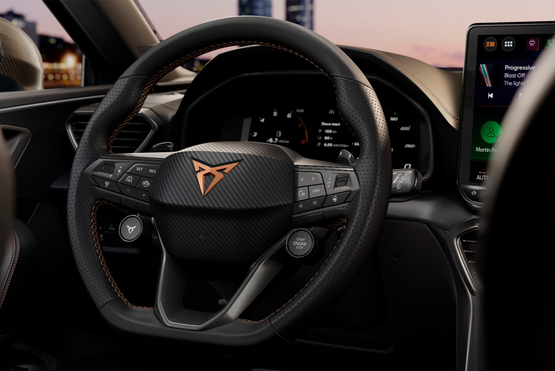 Nahaufnahme der Technologie des CUPRA Leon Sportstourer: Lenkrad mit Satellitentasten, Fahrzeugcockpit, Blick vom Fahrersitz, Außenspiegel, Infotainmentsystem, Armaturenbrett, Türverkleidung, CUPRA-Logo und Fenster.