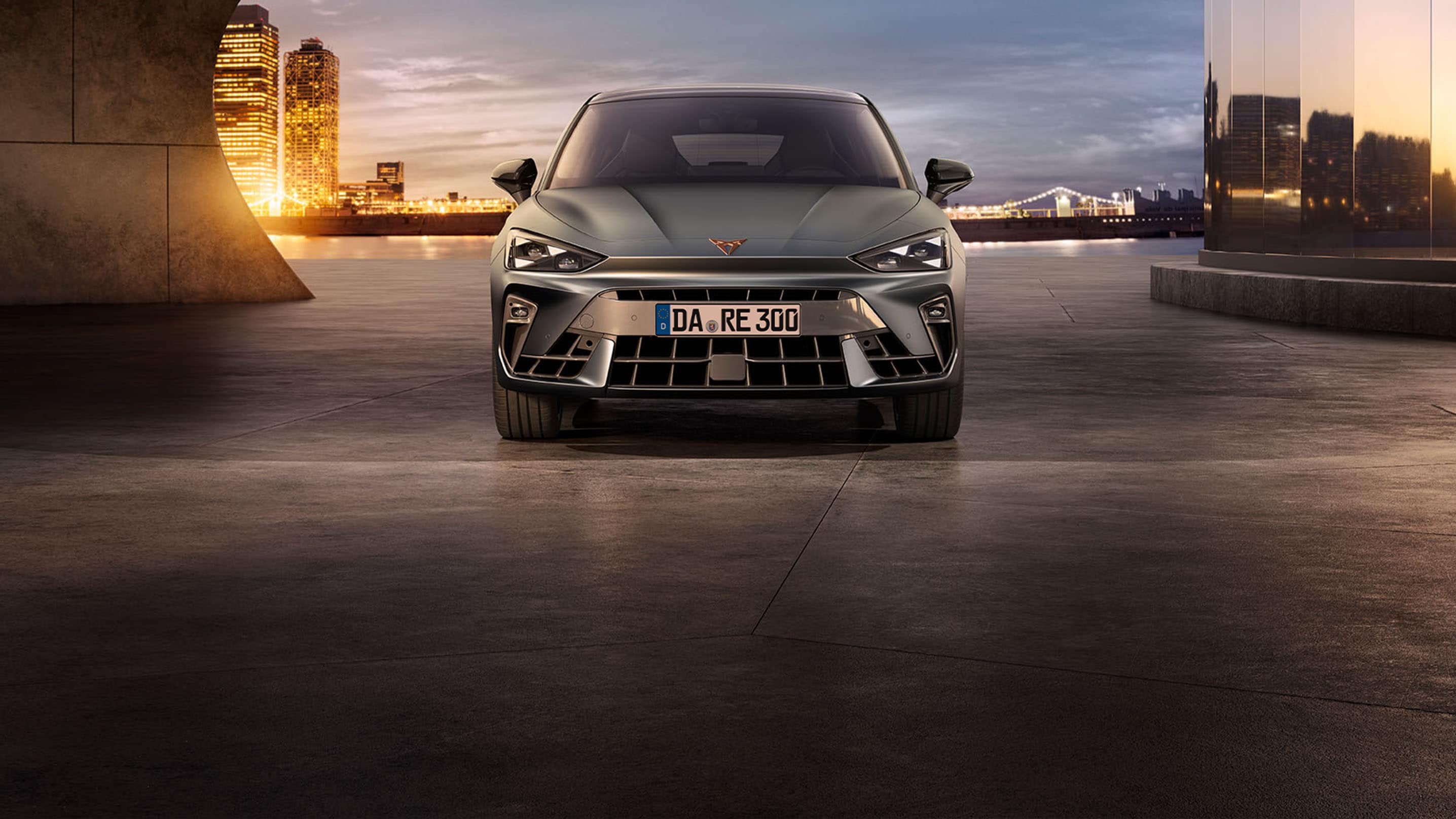CUPRA Leon im Sonnenuntergang vor der Skyline von Barcelona. 