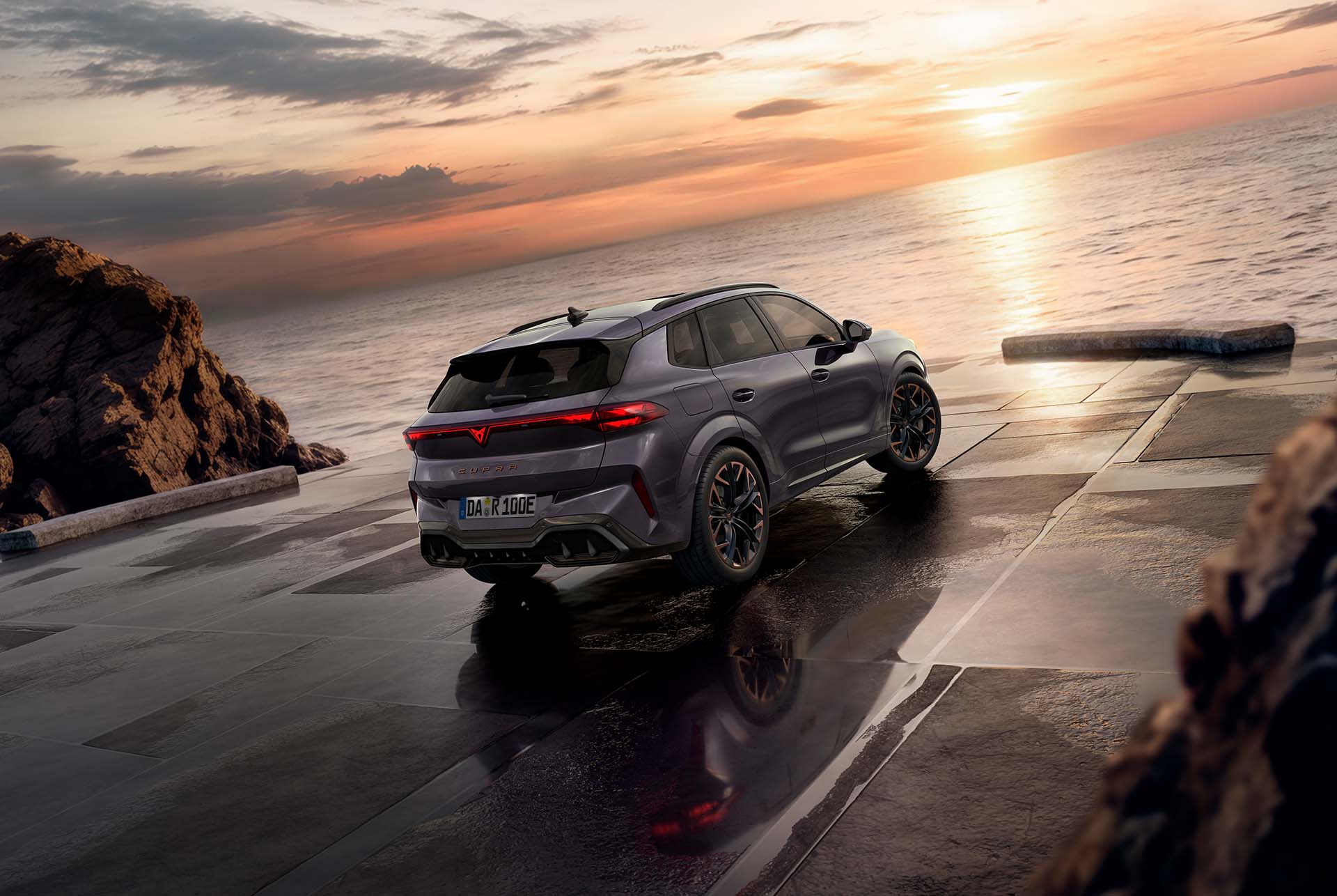 cupra terramar hybrid suv, modell 2024, rückansicht, mit schlanken rückleuchten mit cupra-logo, modernen leichtmetallrädern und einer sportlichen karosserie, auf einem nassen pflaster am meer.
