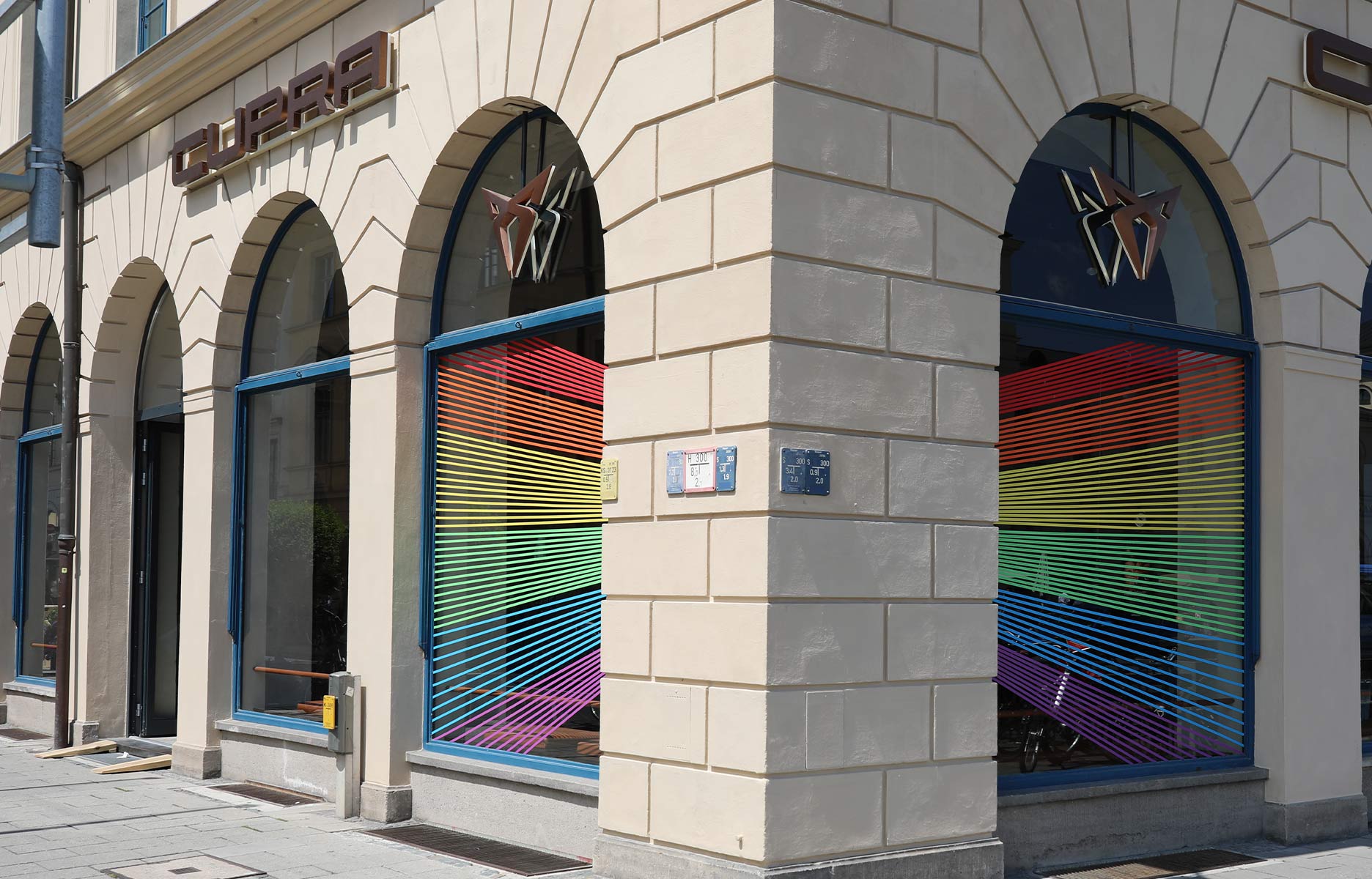 CUPRA City Garage München mit den Regenbogen Farben auf den Fenstern.