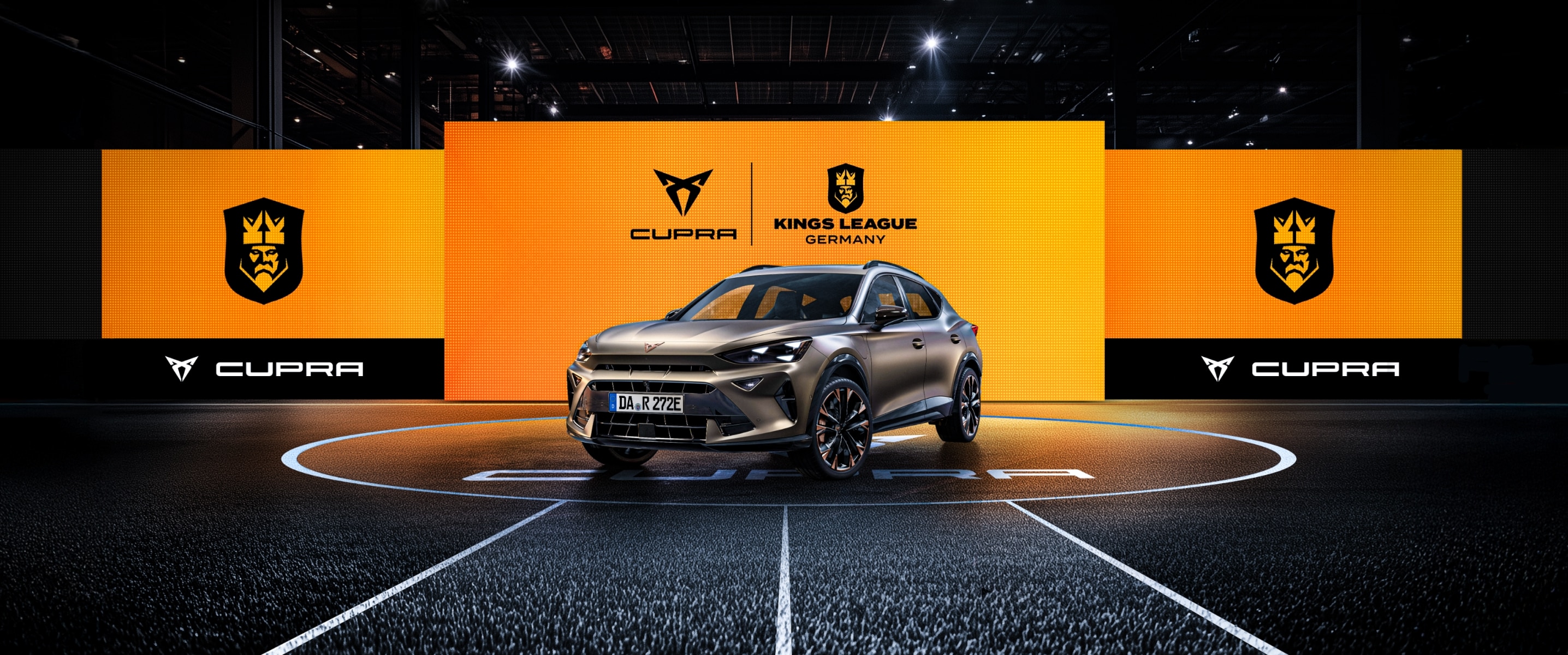 CUPRA Formentor e-HYBRID vor einer Wand aus Screens mit dem CUPRA Logo und dem Kings League Germany Logo. Der CUPRA Formentor e-HYBRID steht im Mittelkreis eines Spielfelds der Kings League.