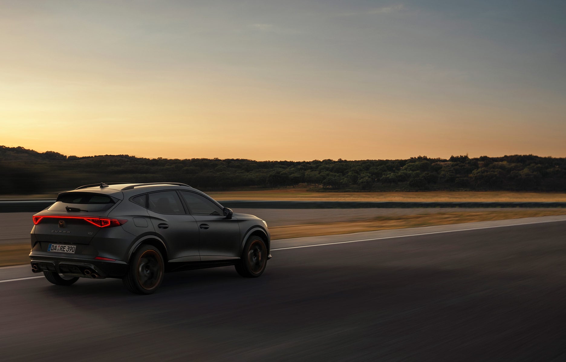 Der CUPRA Formentor VZ5, Seitenansicht auf der Straße, im Hintergrund ein Sonnenuntergang.