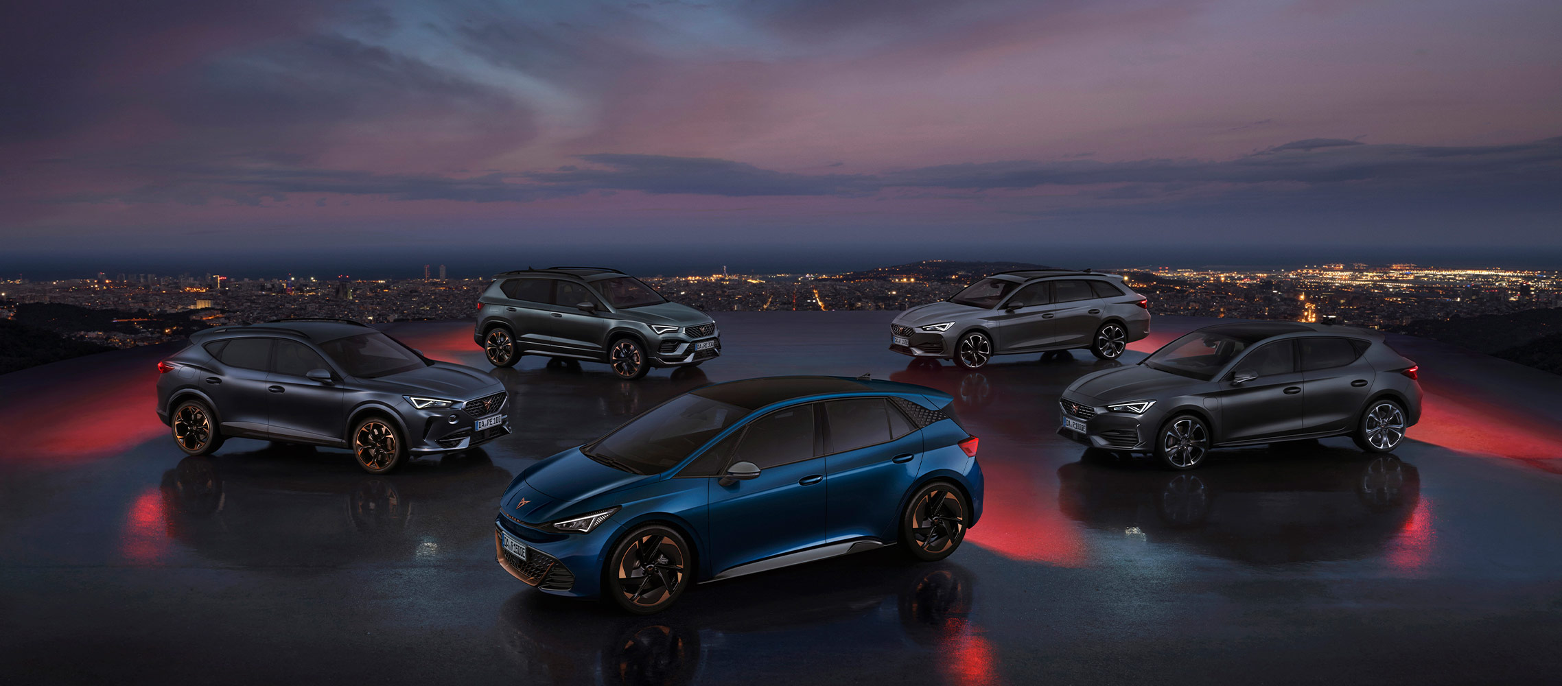 Fahrzeugflotte der CUPRA Fahrzeuge mit dem blauem CUPRA Born in der Mitte, im Hintergrund eine Skyline im Sonnenuntergang.