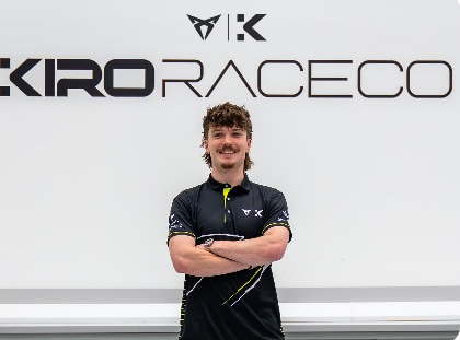 Nahaufnahme von CUPRA KIRO Formel E Fahrer Dan Ticktum im Rennanzug, in die Kamera lächelnd, mit Sonnenbrille. 