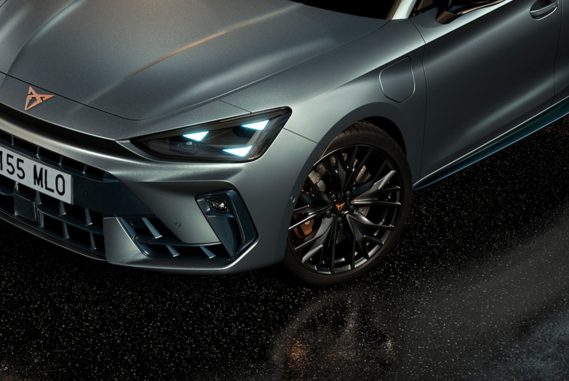 Detailaufnahme der Front des CUPRA Leon VZ Black Edition mit markanter dreieckiger LED-Lichtsignatur und sportlichem 19-Zoll-Leichtmetallrad in Schwarz-Kupfer.
