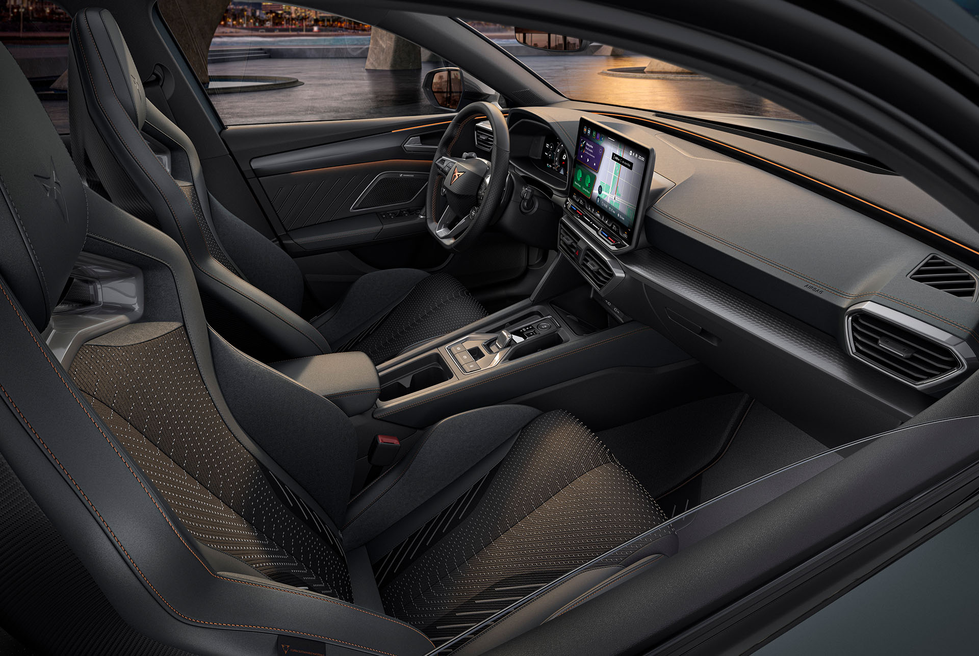 Innenraum des CUPRA Leon mit Infotainment Bildschirm und sportlichen Schalensitzen.