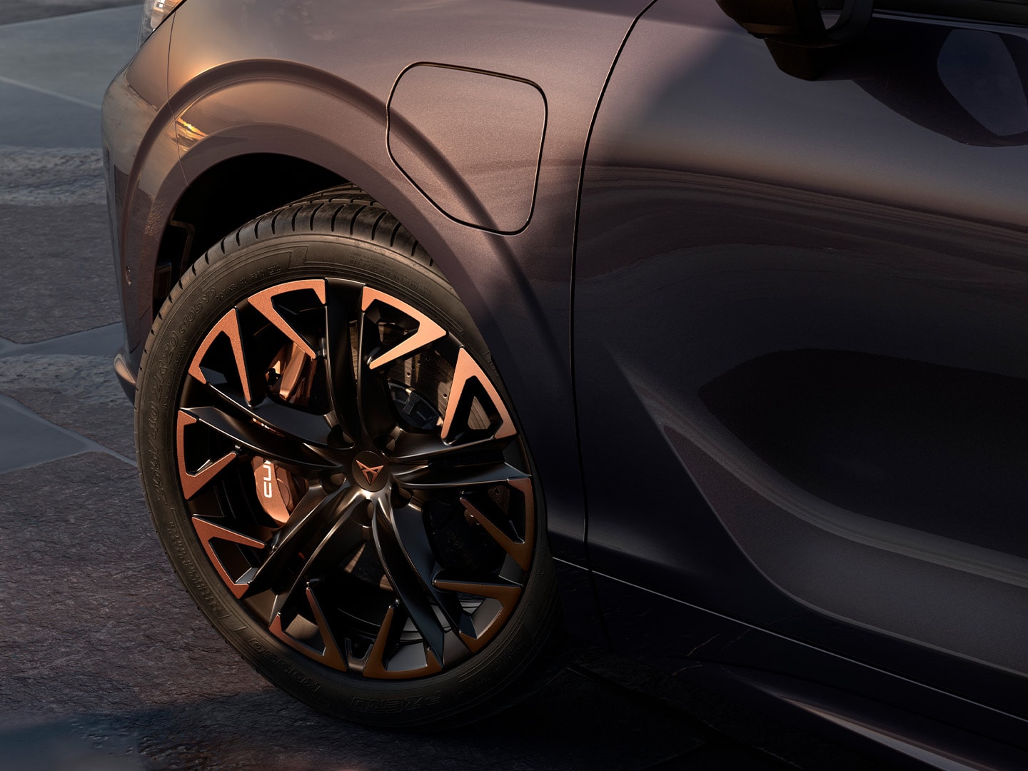 Seitenansicht des CUPRA Terramar in der Lackierung „Maximum Braking Power“, geparkt an der Küste, wobei die dunkle „Void“-Lackierung und die 20-Zoll-Leichtmetallfelgen in der Farbe „Hadron Copper“ besonders hervorstechen.