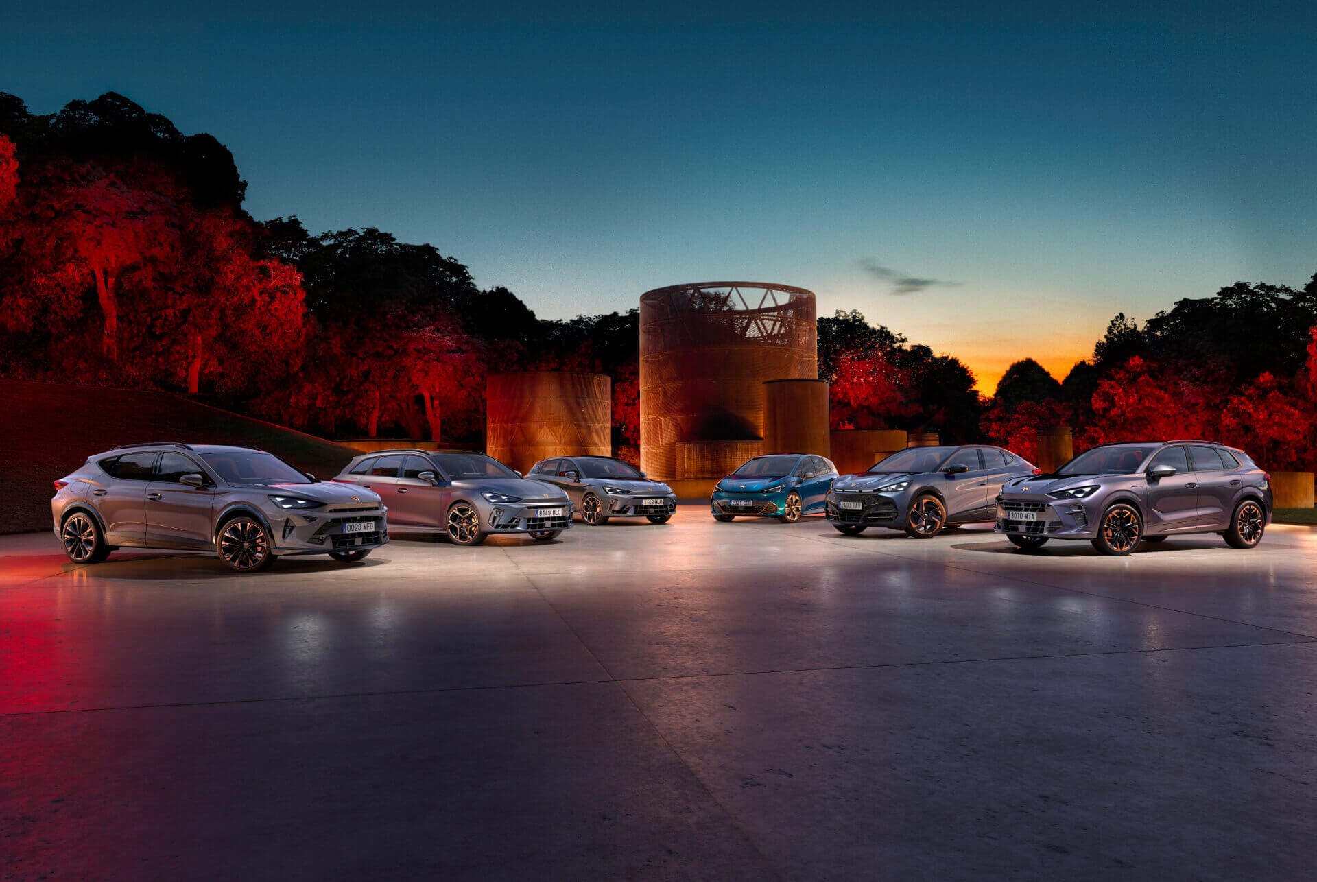 Sechs CUPRA Elektrofahrzeuge auf einem Parkdeck– futuristische Darstellung der Elektromobilität mit urbanem Skyline-Hintergrund.