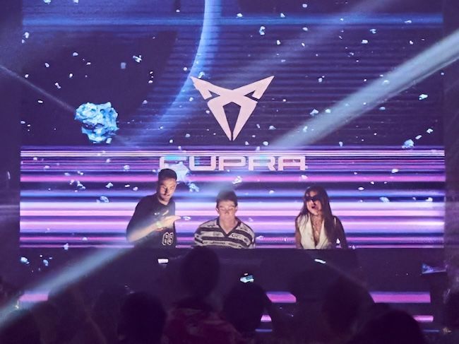 CUPRA Event mit DJs auf der Bühne – futuristisches Lichtdesign, pulsierende Beats und eine begeisterte Crowd. Die Marke CUPRA verbindet Performance mit urbaner Clubkultur.